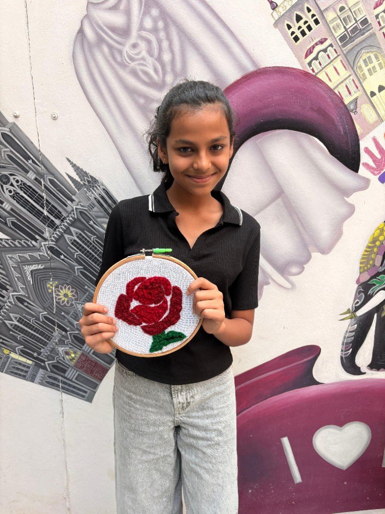 Kid with finished embroidered artwork